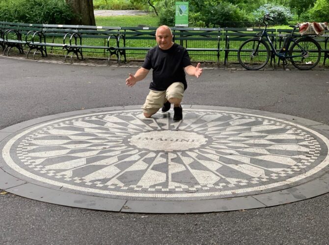 Asef en la atracción más fotografiada de los Strawberry Fields, el mosaico en blanco y negro con la palabra «Imagine» ubicado en el centro de la plazoleta